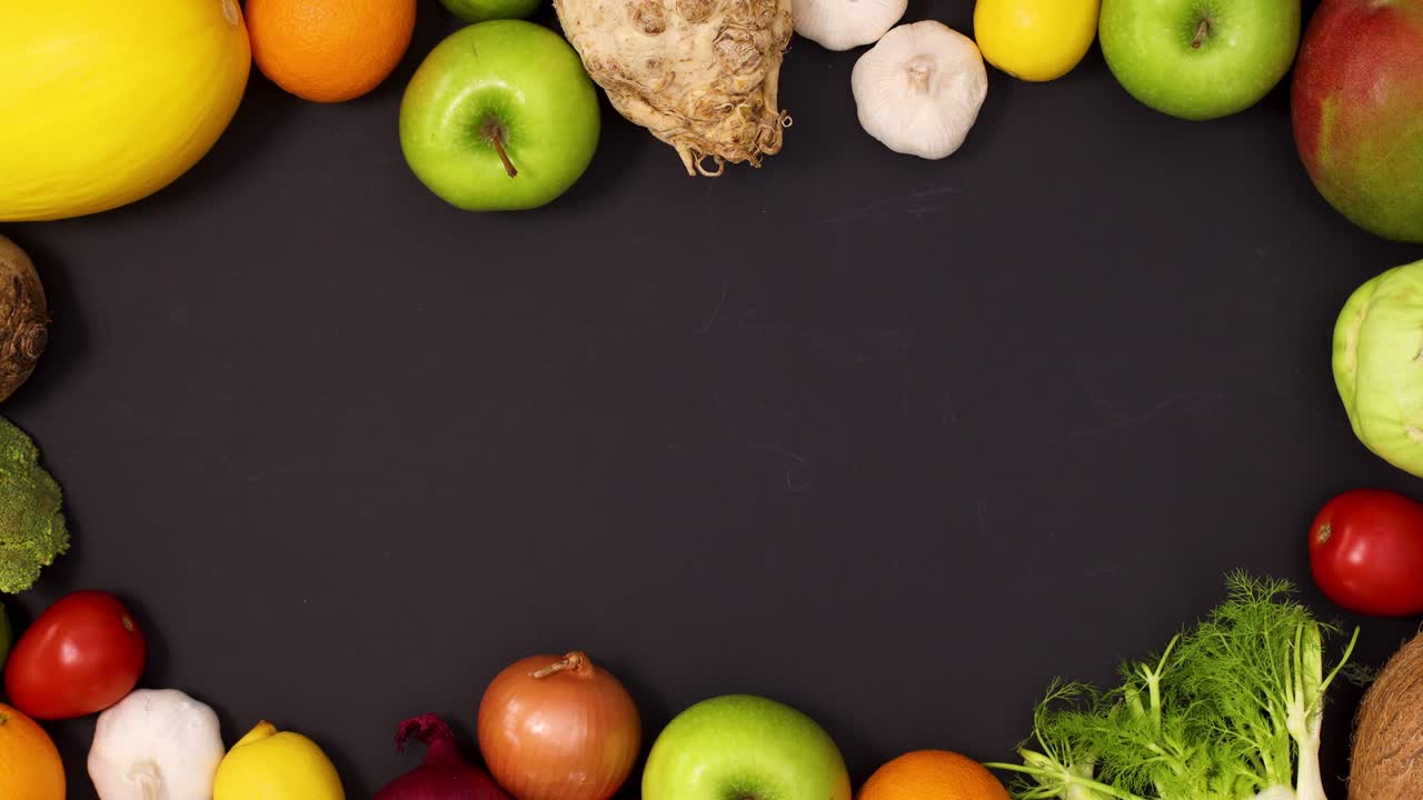 marco vibrante hecho de frutas y verduras frescas sobre un fondo negro.