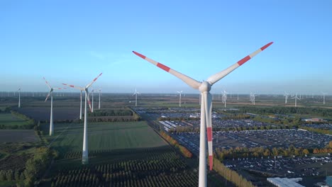 close up wind turbine next to huge factory