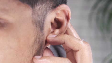 close-up of a person touching their ear