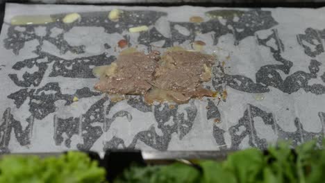 una fina loncha de carne en la parrilla con papel de horno