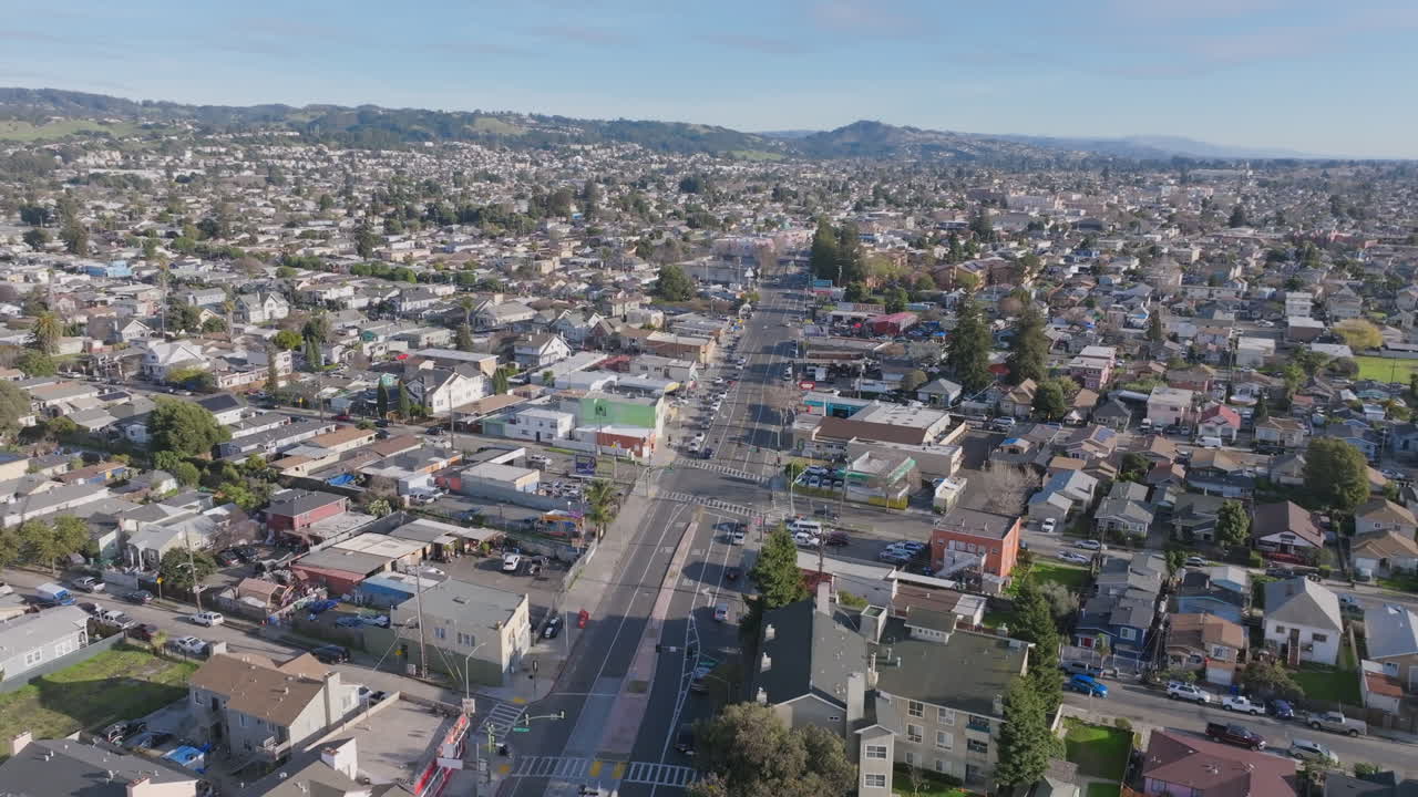 Drone aerial footage flying over a main boulevard in south Oakland, CA in the light of the sunset.