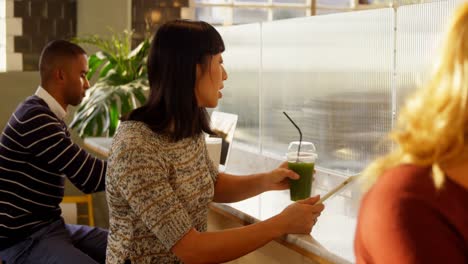 Woman-using-digital-tablet-while-having-juice-4k