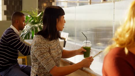 woman using digital tablet while having juice 4k