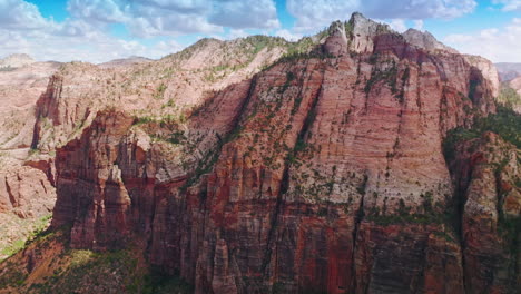 approaching enormous pink rocks zion canyon in utah, united states. stunning mountains at the backdrop of blue cloudy sky.