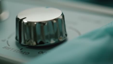 a focused view of a metallic control knob used in a medical setting. the equipment is situated in a surgical room, indicating precise adjustments for operations.