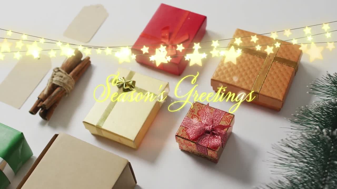 Animation of season's greetings text with fairy lights over presents
