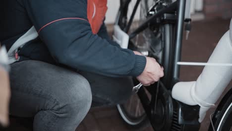 bicycle mechanic installs and tightens pedals on a new electric bike that is still wrapped in foam from taking it out of the box