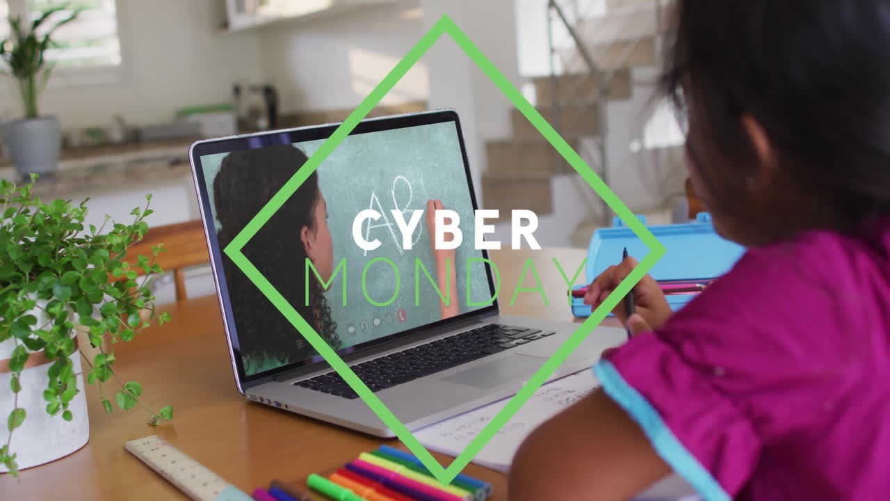 At home, child drawing while animation of Cyber Monday shown on laptop screen