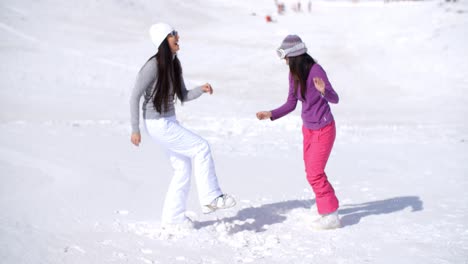 Zwei-Junge-Frauen-Tummeln-Sich-Im-Winterschnee