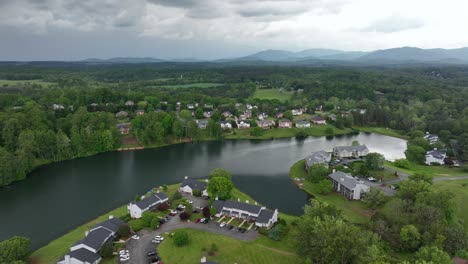 aerial panorama modern townhouses and homes at lake in virginia. dark cloudy day in forest landscape. quiet and green scenery of united states.