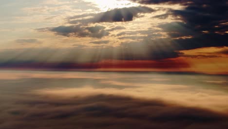 mystical sunrise drone shot above clouds with golden rays shining through mist