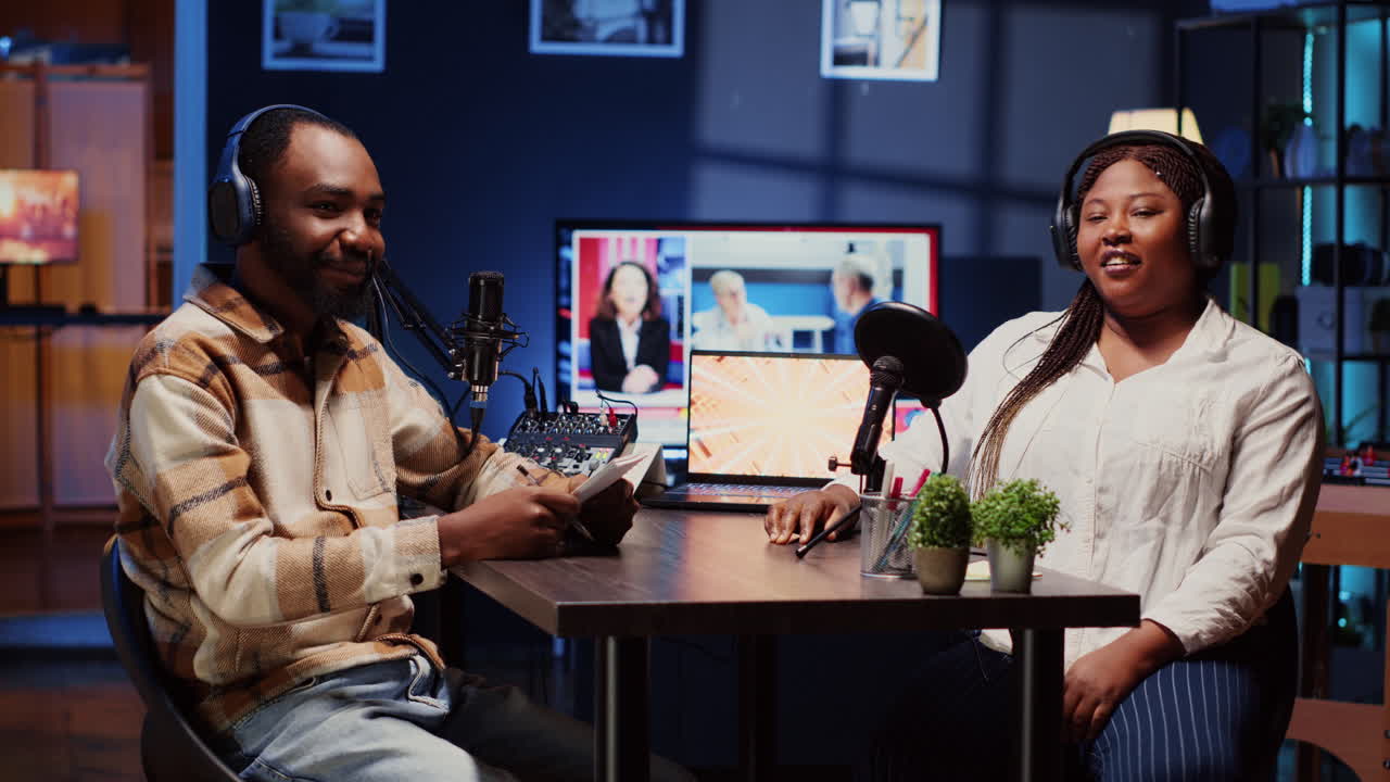 Vlogger show host and guest talking in neon lights ornate living room personal studio