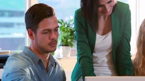 Casual-business-team-using-laptop-during-meeting-