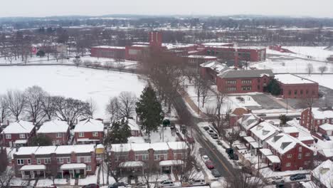 Aerial-of-urban-city-housing-in-USA-with-school-buildings-in-distance