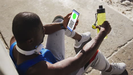 hombre sentado en la calle sosteniendo un teléfono inteligente con certificado de vacunación contra la covid y código qr en la pantalla