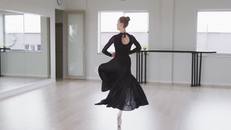 caucasian female ballet dancer practicing ballet during a dance class in a bright studio