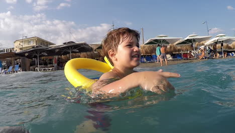 Imágenes-De-Un-Niño-Caucásico-Divirtiéndose-Con-Olas-En-La-Playa-De-Kalamata,-Grecia