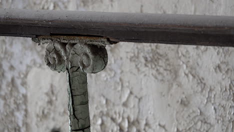 Ornamental-ironwork-on-railing-at-19th-century-prison-with-cracked-paint