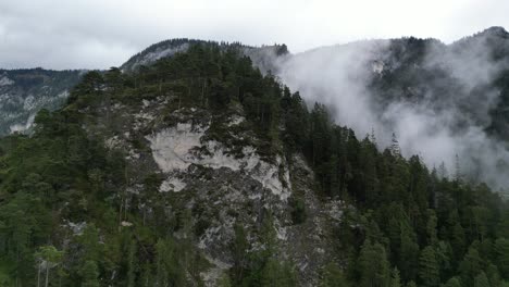 Mist-drifting-through-tree-line-on-mountainside-Bavaria-Germany-Drone-Aerial-view