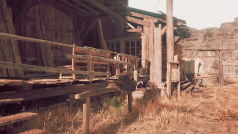 a rustic wooden building in the desert with a saddle and a bench outside