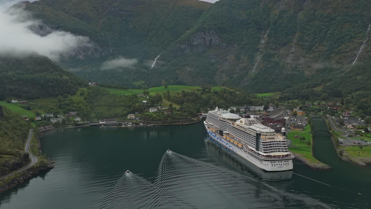 Filmagens aéreas de navio de cruzeiro atracado na pitoresca Flam, aninhada nos fiordes da Noruega.