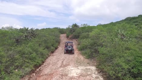 Toma-Aérea-Siguiendo-A-Un-Auto-En-Un-Camino-De-Tierra-En-Querétaro,-México