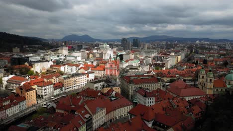 Vista-Cinematográfica-De-Drones-De-La-Iglesia-Franciscana-De-La-Anunciación-Y-Del-Centro-De-La-Ciudad-De-Liubliana-En-Tiempo-Nublado.