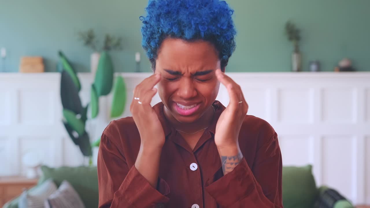 Young sick african american woman suffers from migraines or panic attacks