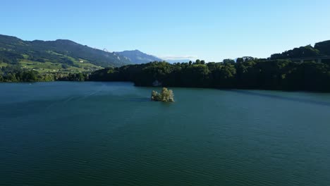 orbit drone shot of a small island on the lake of gruyere in canton of fribourg in switzerland