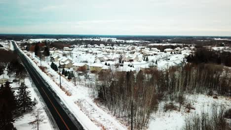 aerial flyover 19th century farmhouse to reveal 21st century townhouse community during winter. 4k