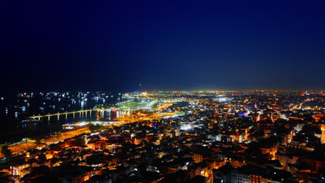 rising over the luminous panorama of istanbul, turkey. boats with lights on at the dark waterscape at backdrop