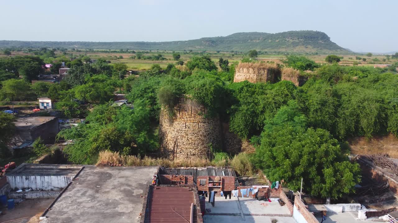 Drone shot of a fort covered with forest in a village of north india