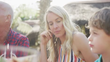 Happy-caucasian-family-having-dinner-and-talking-in-garden