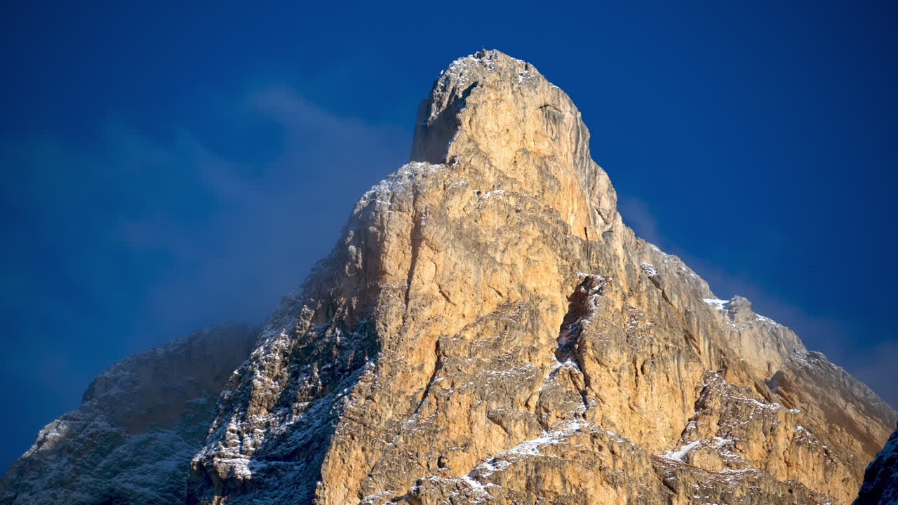 View of snow on the mountains in the Dolomites, Italy with the moon on the cloudy sky on the background