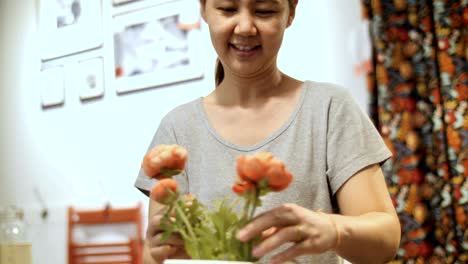 4k mujer asiática cortando flores y arreglando hermosas flores en un jarrón de flores