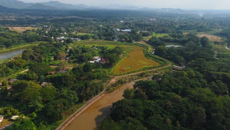 Aerial view of a rural village and farmland in Thailand