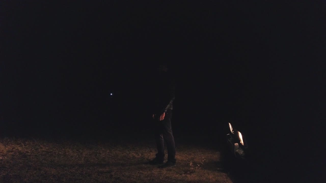 persona de noche en el campo con luz