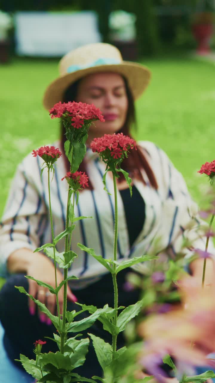 A Peaceful Moment Amidst Vibrant Flowers: A Woman in a Straw Hat Meditating in a Lush Green Garden, Embracing Serenity and Nature's Beauty