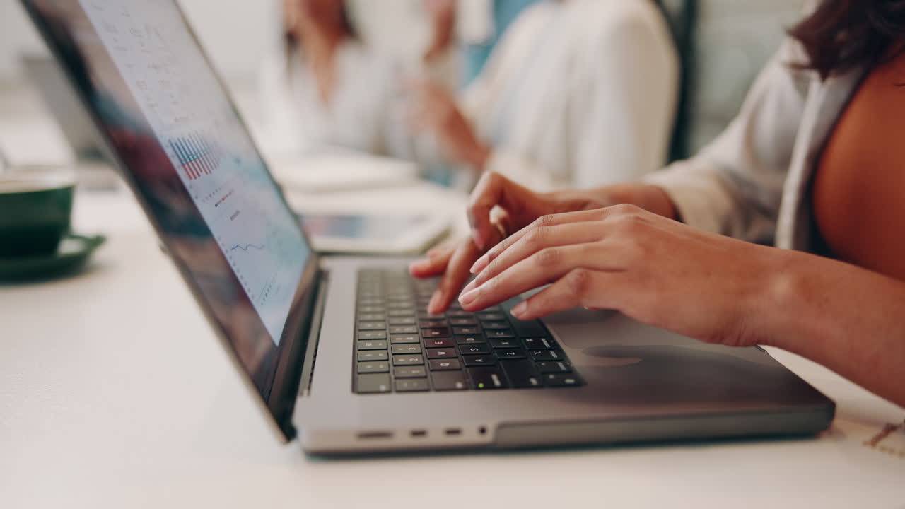 Woman Typing on Laptop in Business Meeting