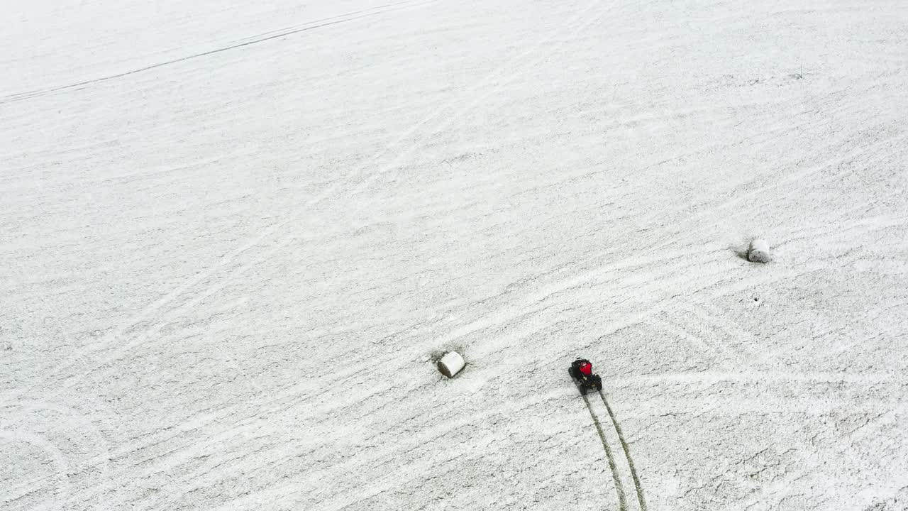 vista de arriba hacia abajo de un hombre montando un atv en hierba llena de nieve