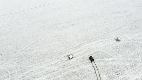 Vista-De-Arriba-Hacia-Abajo-De-Un-Hombre-Montando-Un-Atv-En-Hierba-Llena-De-Nieve