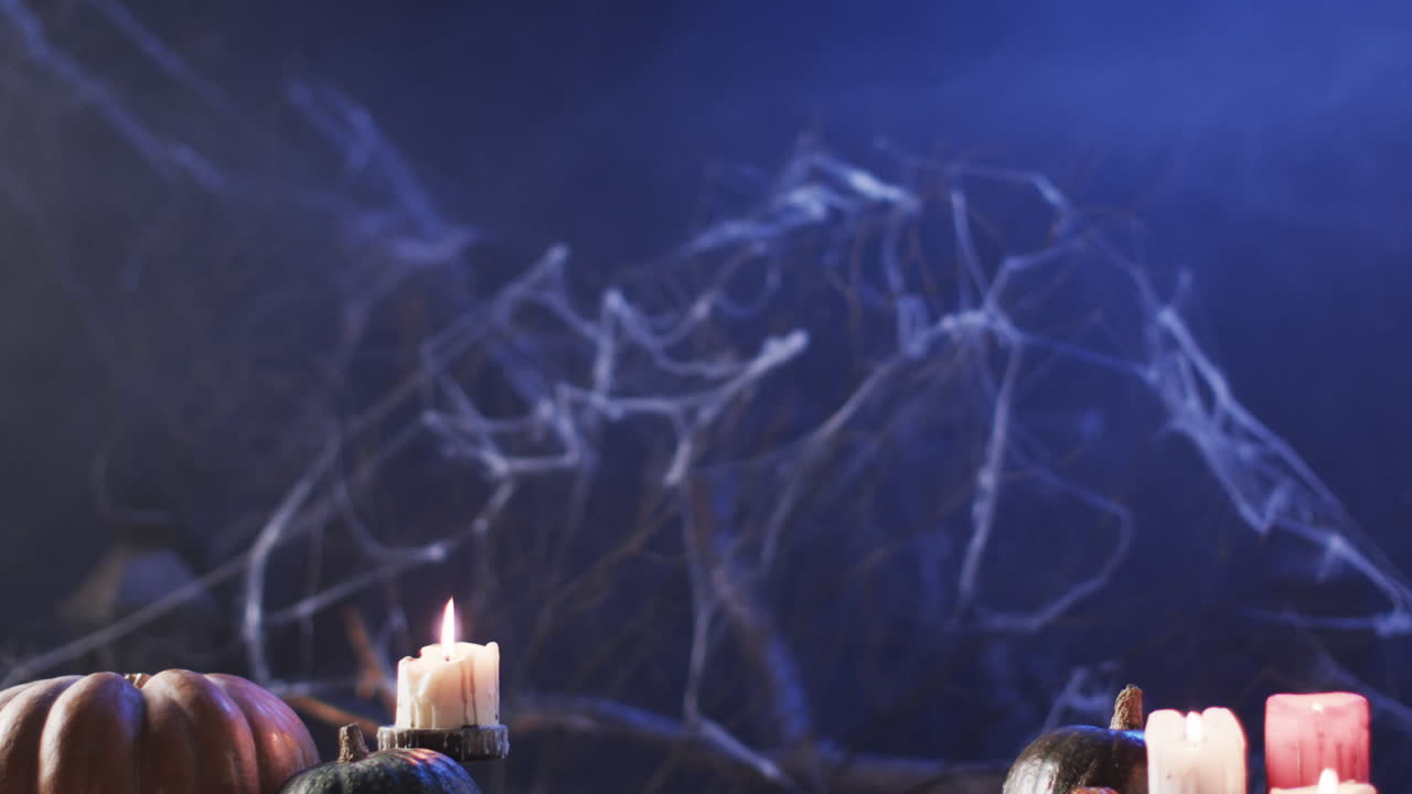 En Halloween-tema opsætning med stearinlys og græskar, med plads til tekst