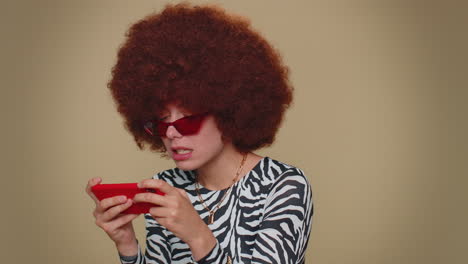 Worried-funny-young-woman-enthusiastically-playing-racing-or-shooter-video-games-on-smartphone