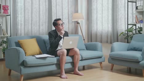 hombre trabajando desde casa en el sofá con una computadora portátil