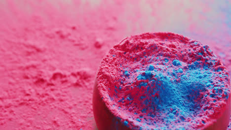 video of pink and blue coloured powders and bowl with copy space on black background