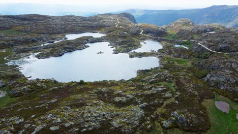 aerial swooping descends over presa los garandones open lake in mountains of spain