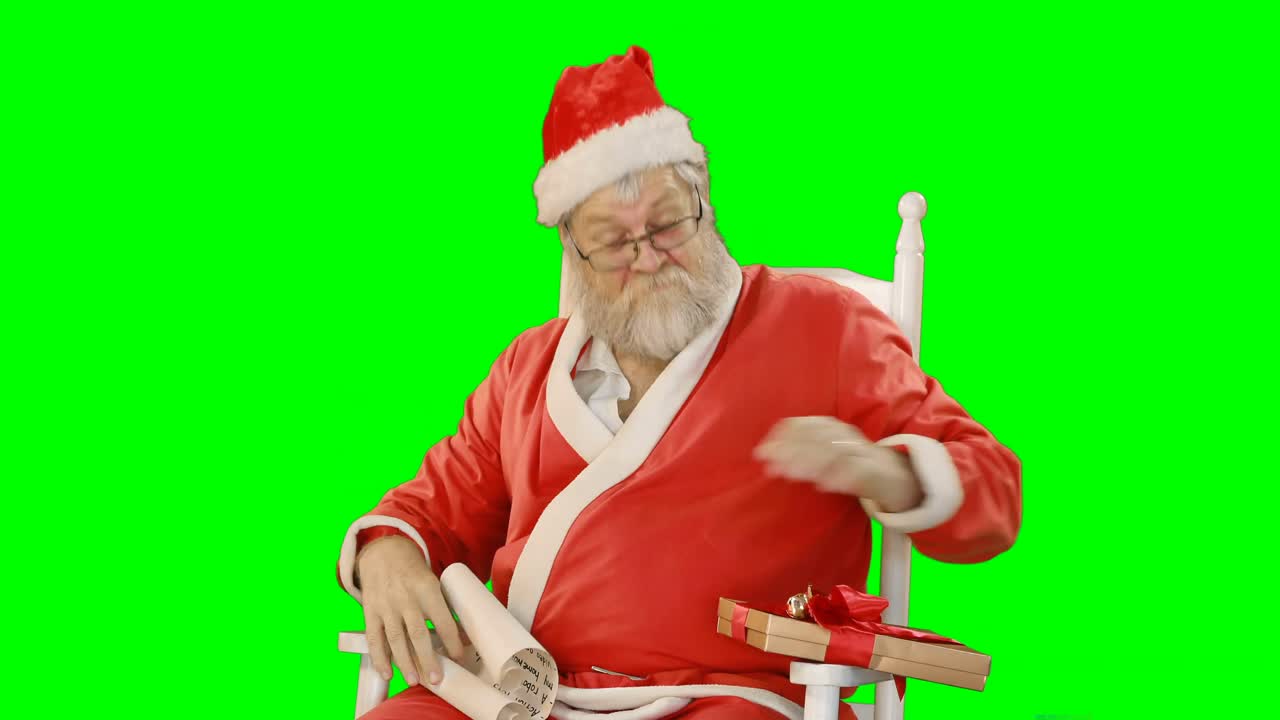 산타클로스 는 스크롤 과 선물 상자 를 들고 있다