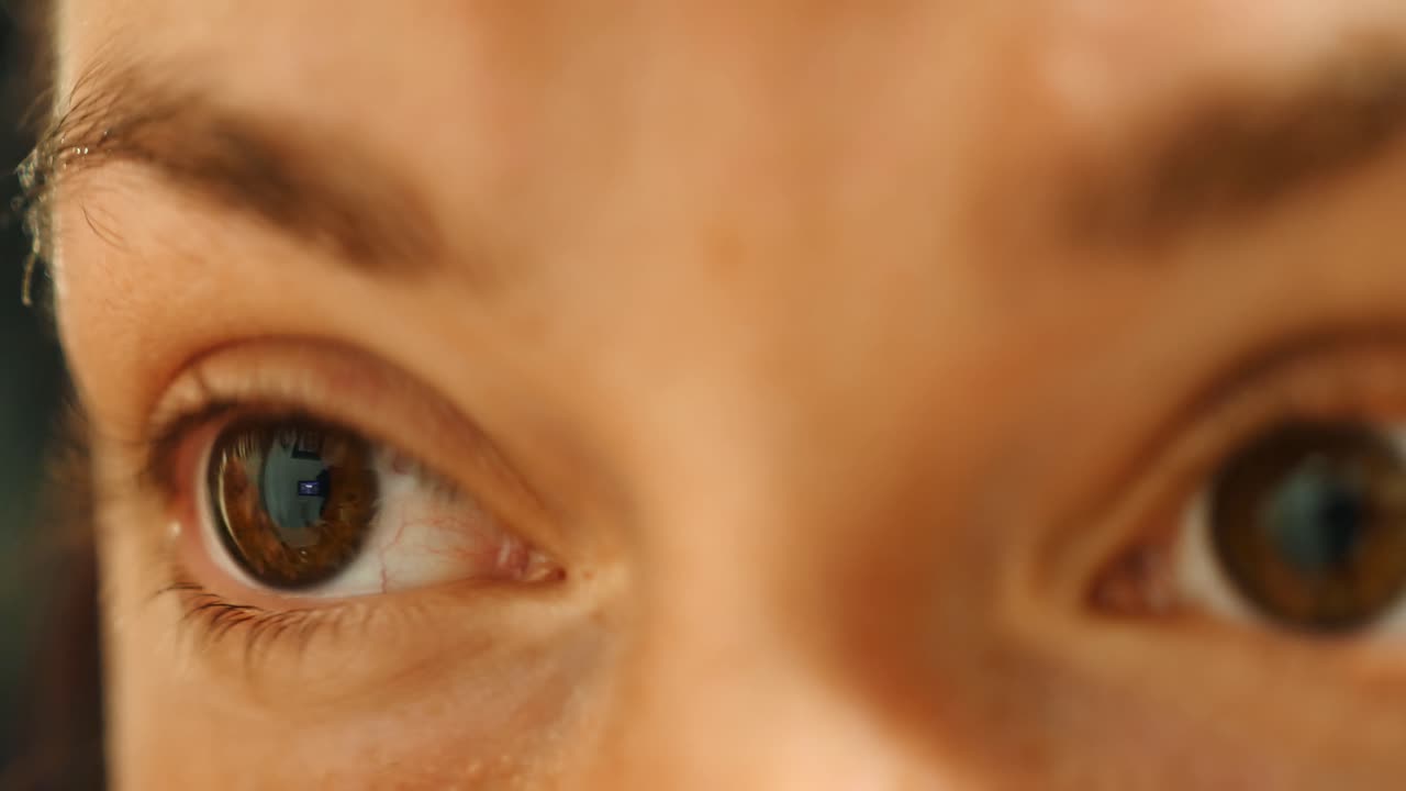 primer plano de mujer con ojos marrones depilarse las cejas