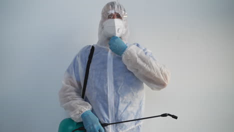 en equipo de protección personal rociando desinfectante