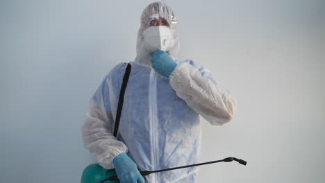 person in protective gear spraying disinfectant